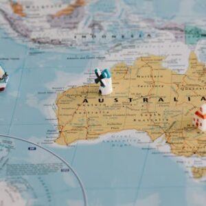 Miniature windmill and ship placed atop a map of Australia, highlighting travel concepts.