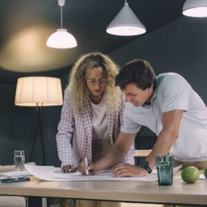 Two professionals collaborating over a project in a modern office setting.