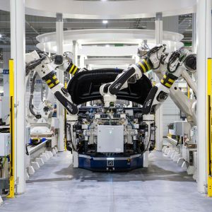 High-tech robots assembling a car in a modern factory setting, showcasing automation.