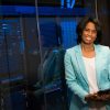 Smiling woman in data center showcasing technology expertise.