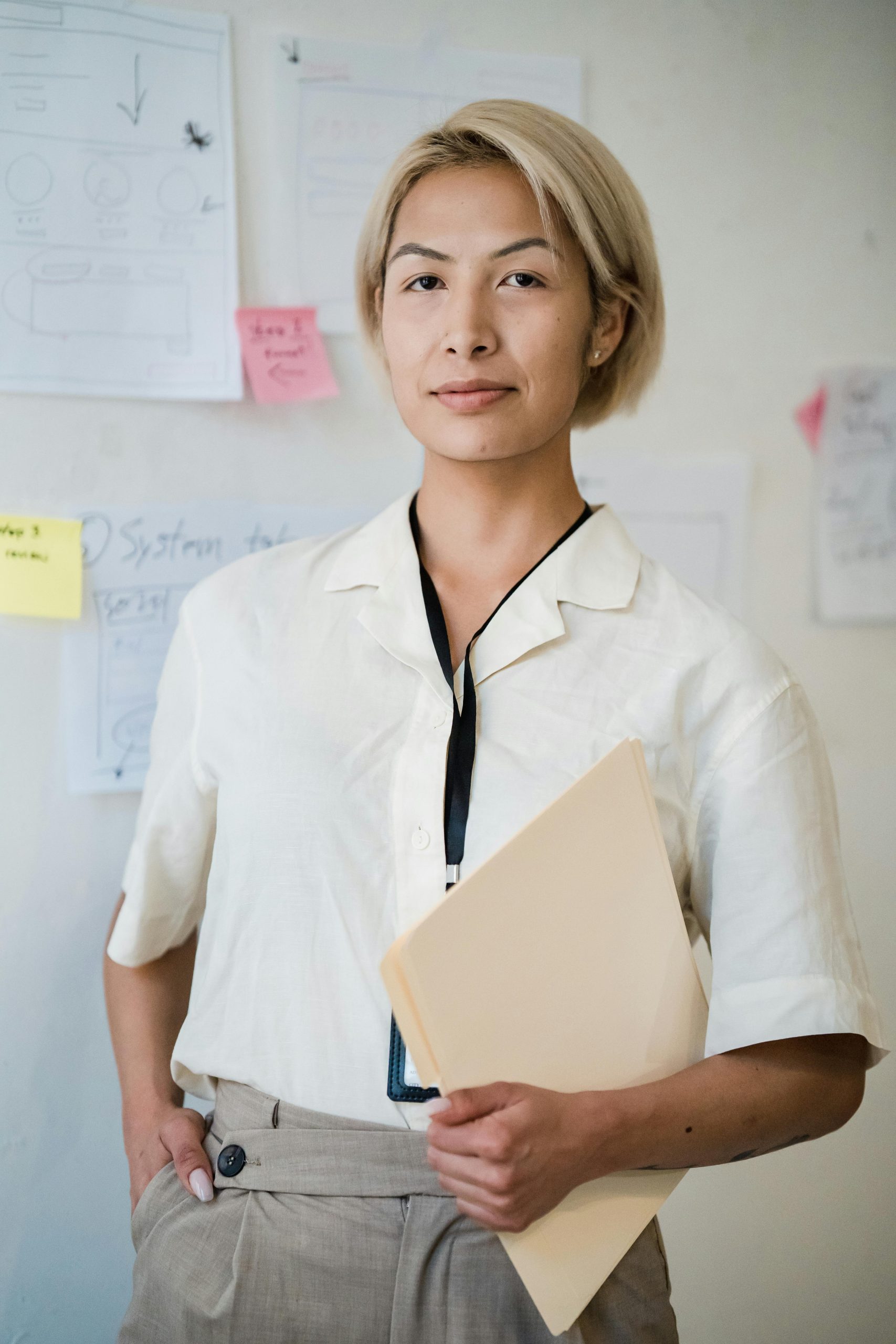 Professional woman holding documents in an office setting, exuding confidence and poise.