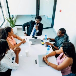 A group of professionals engaged in a business discussion around a table in a Lagos office.
