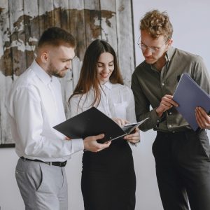 Professional team engaged in a meeting, reviewing documents together in a modern office space.