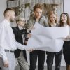 Group of professionals in an office setting analyzing project plans together.