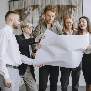 Group of professionals in an office setting analyzing project plans together.