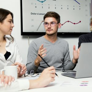 Group of colleagues discussing strategy with charts in the background.