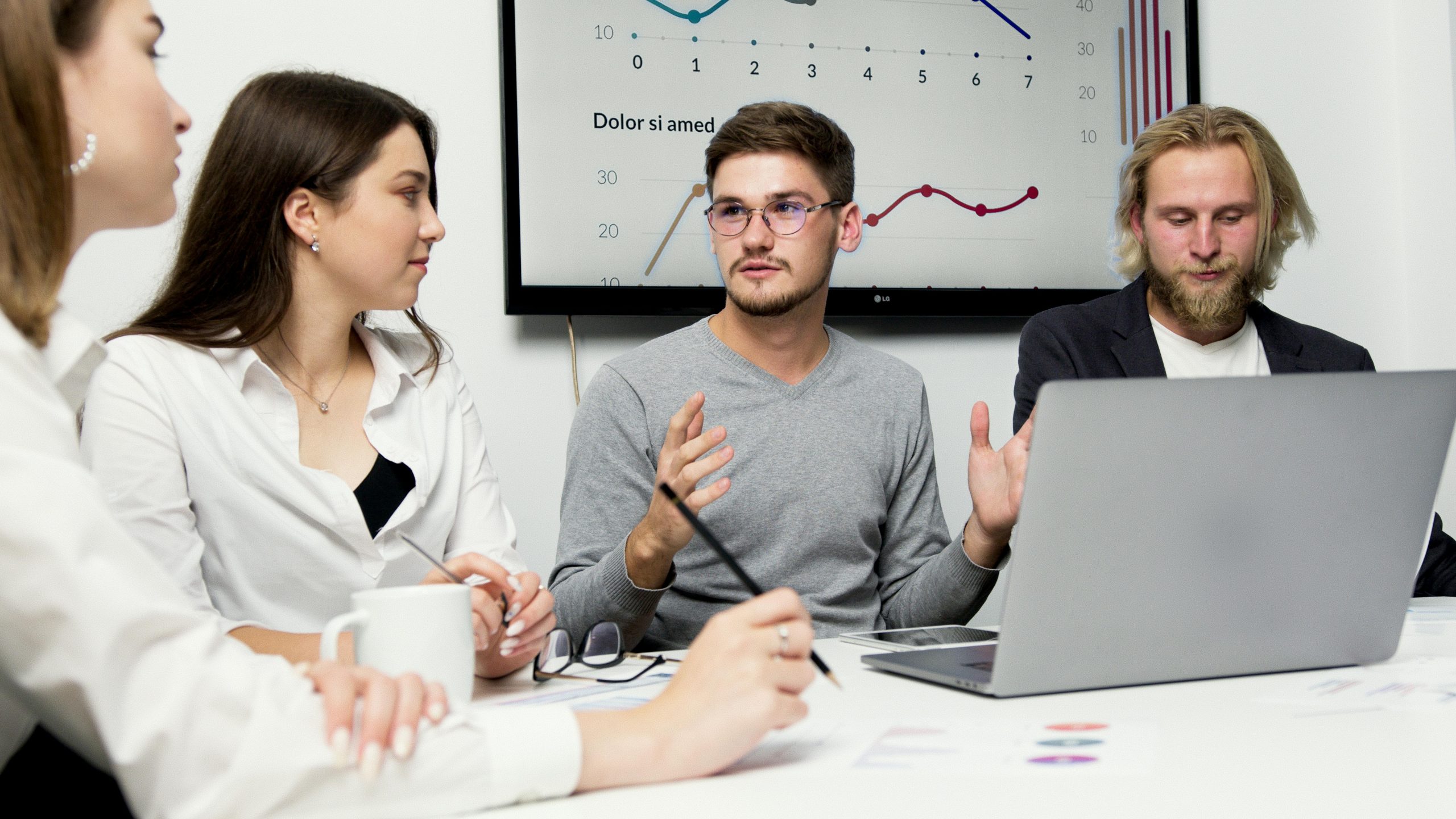 Group of colleagues discussing strategy with charts in the background.