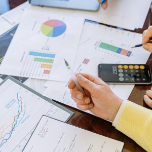 A close-up of businesspeople analyzing financial data and charts during a meeting.