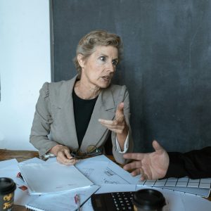Mature businesswoman discussing plans with colleagues in an office setting.