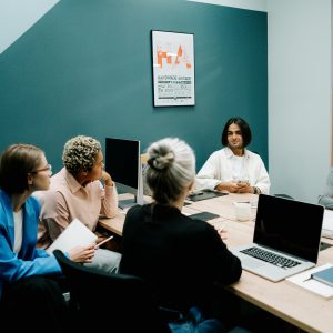 A diverse group of professionals engaged in a dynamic meeting in a modern office environment.