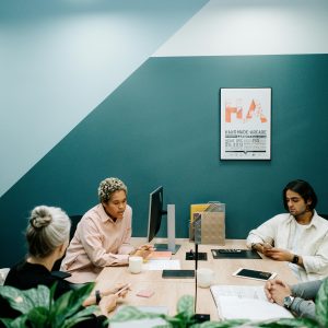 A group of diverse professionals engaged in a team meeting in a contemporary office environment.