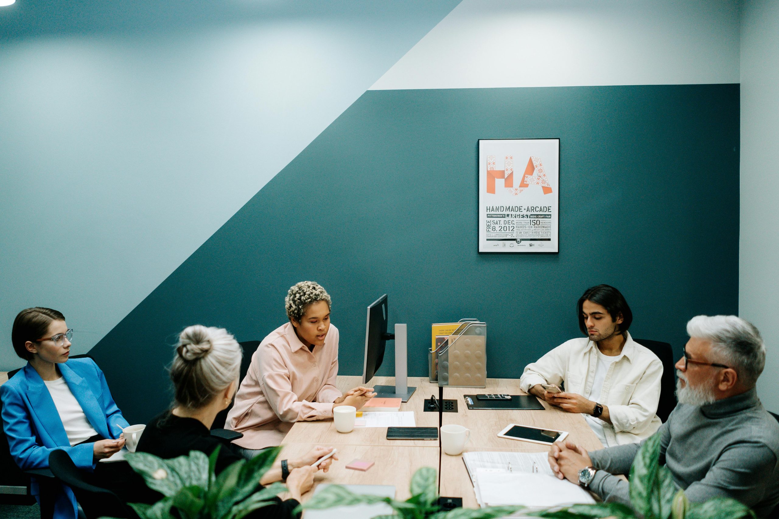 A group of diverse professionals engaged in a team meeting in a contemporary office environment.