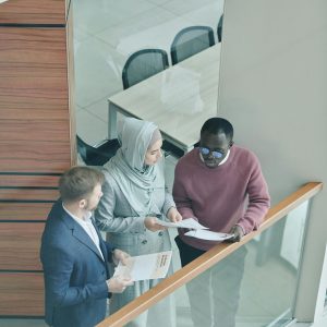 A diverse group of professionals discussing documents in a modern office setting.