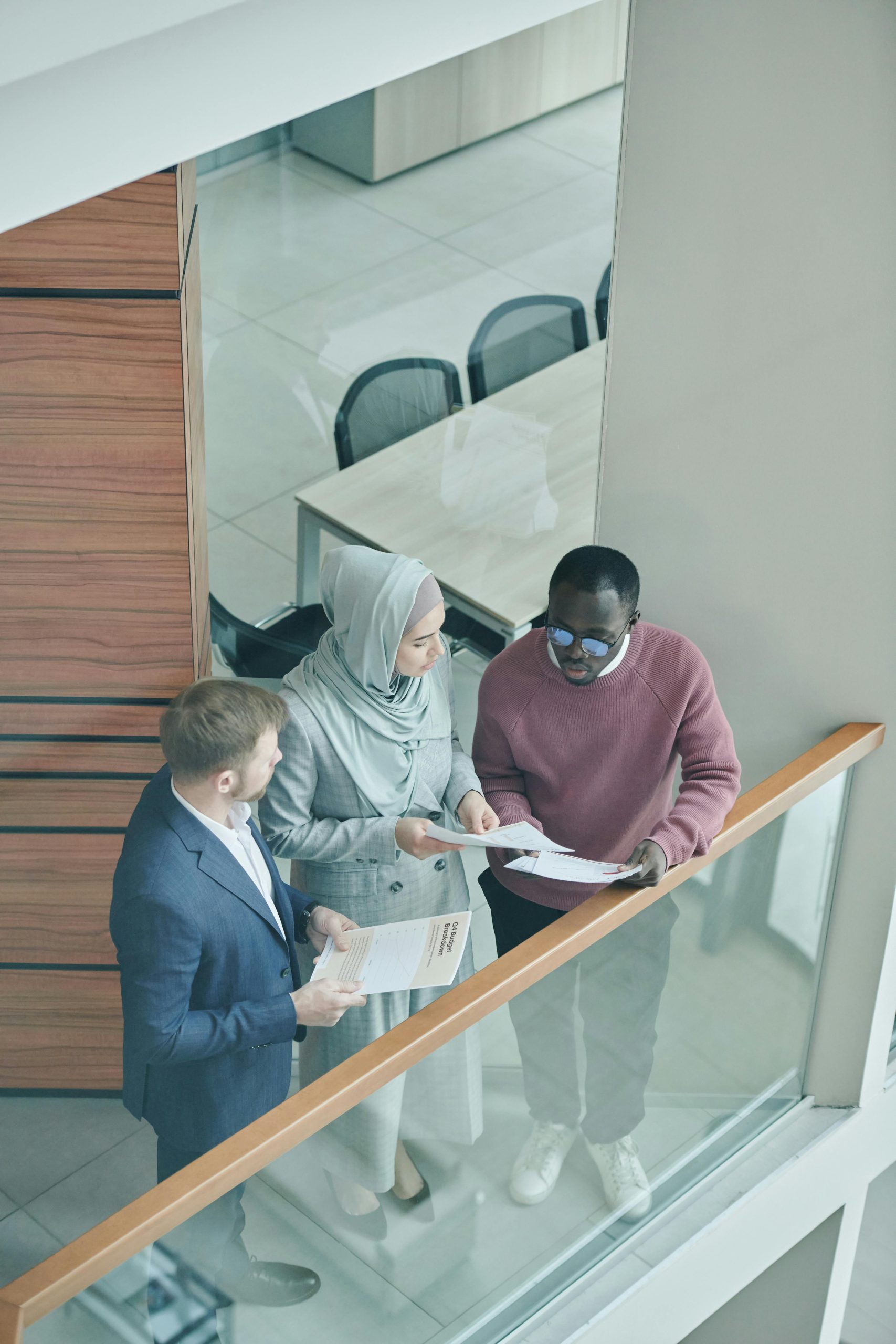 A diverse group of professionals discussing documents in a modern office setting.