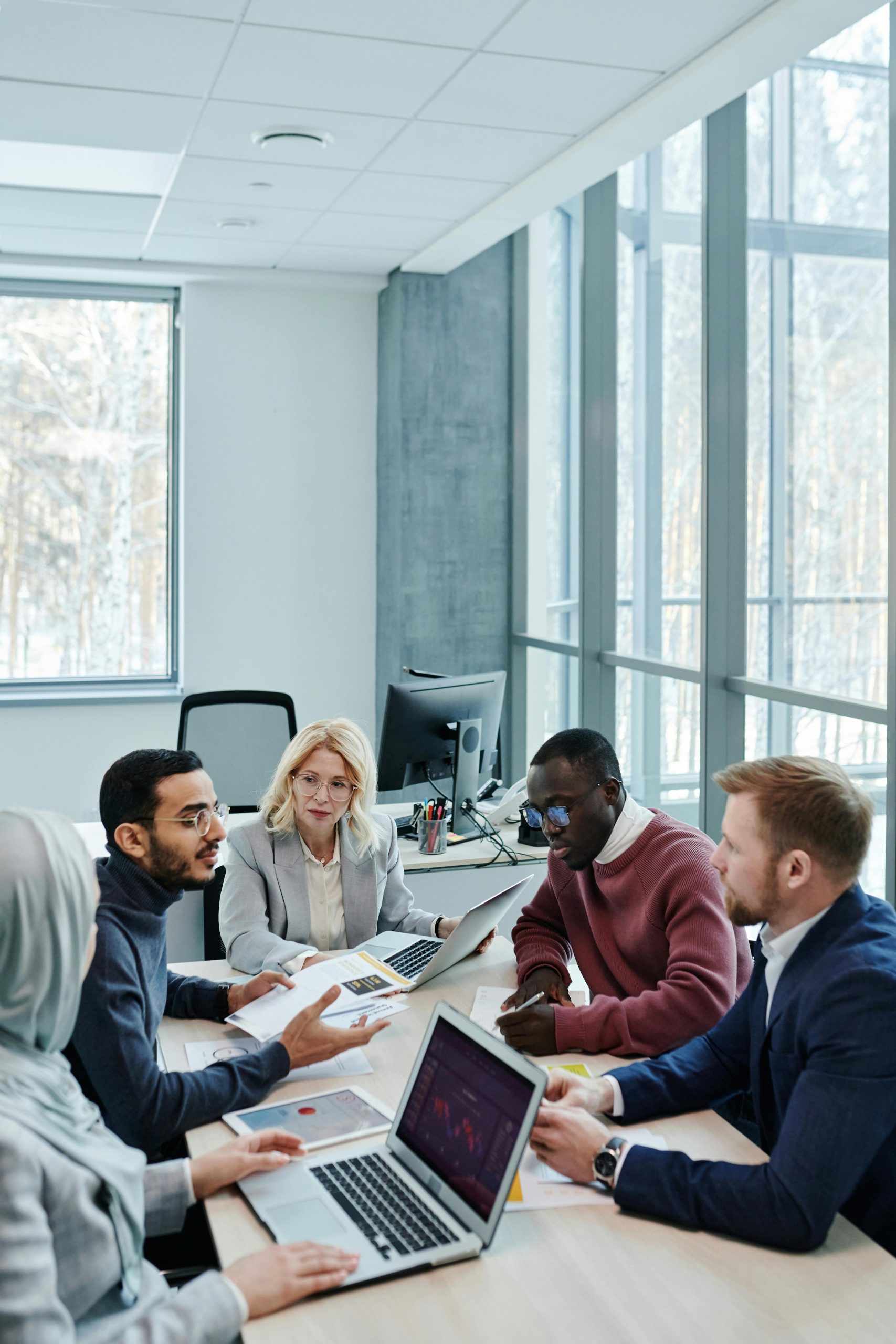 A diverse group of colleagues working together on a project in a bright, modern office environment.
