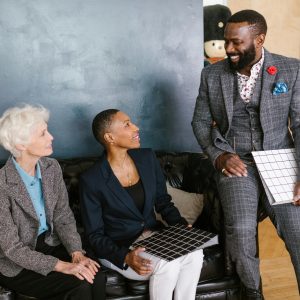 Three diverse business professionals engaging in a friendly meeting indoors.