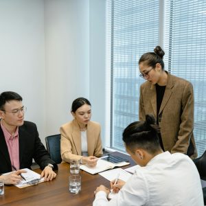 A group of business professionals engaged in a team meeting in a modern office setting.
