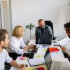 A diverse group of professionals collaborates in a modern office setting, fostering teamwork.