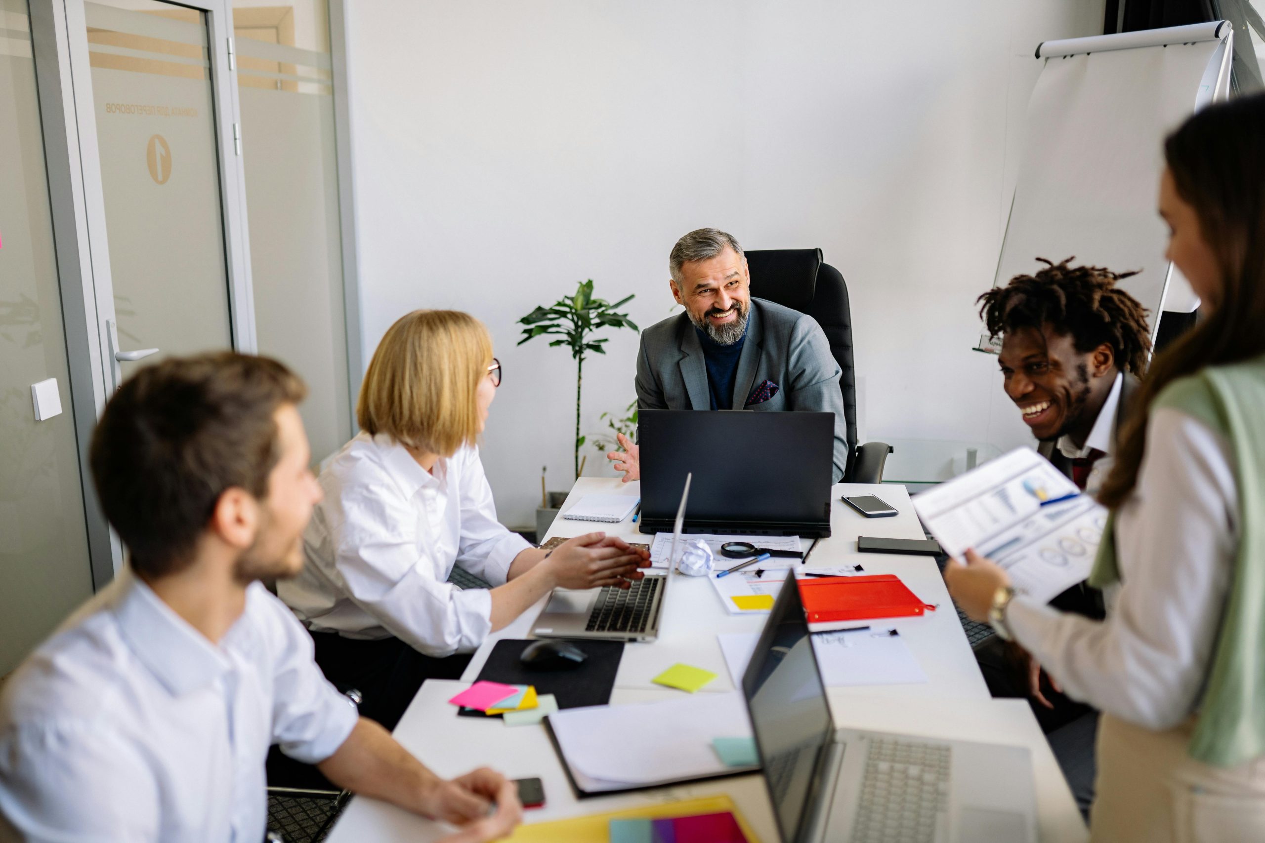 A diverse group of professionals collaborates in a modern office setting, fostering teamwork.