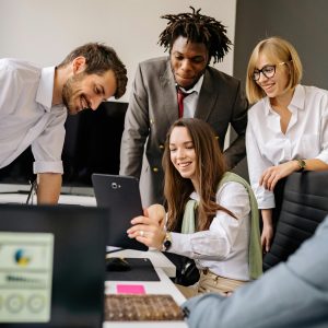 A diverse office team collaborates with technology in a modern workplace.