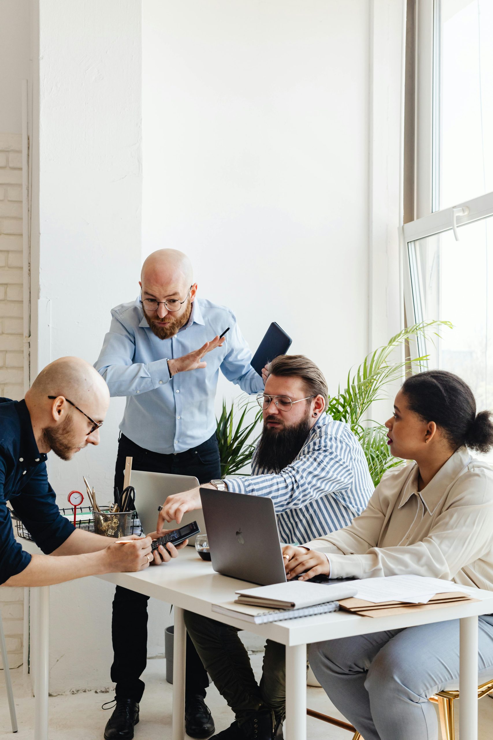 Group of professionals working together in a bright office, focusing on teamwork and collaboration.