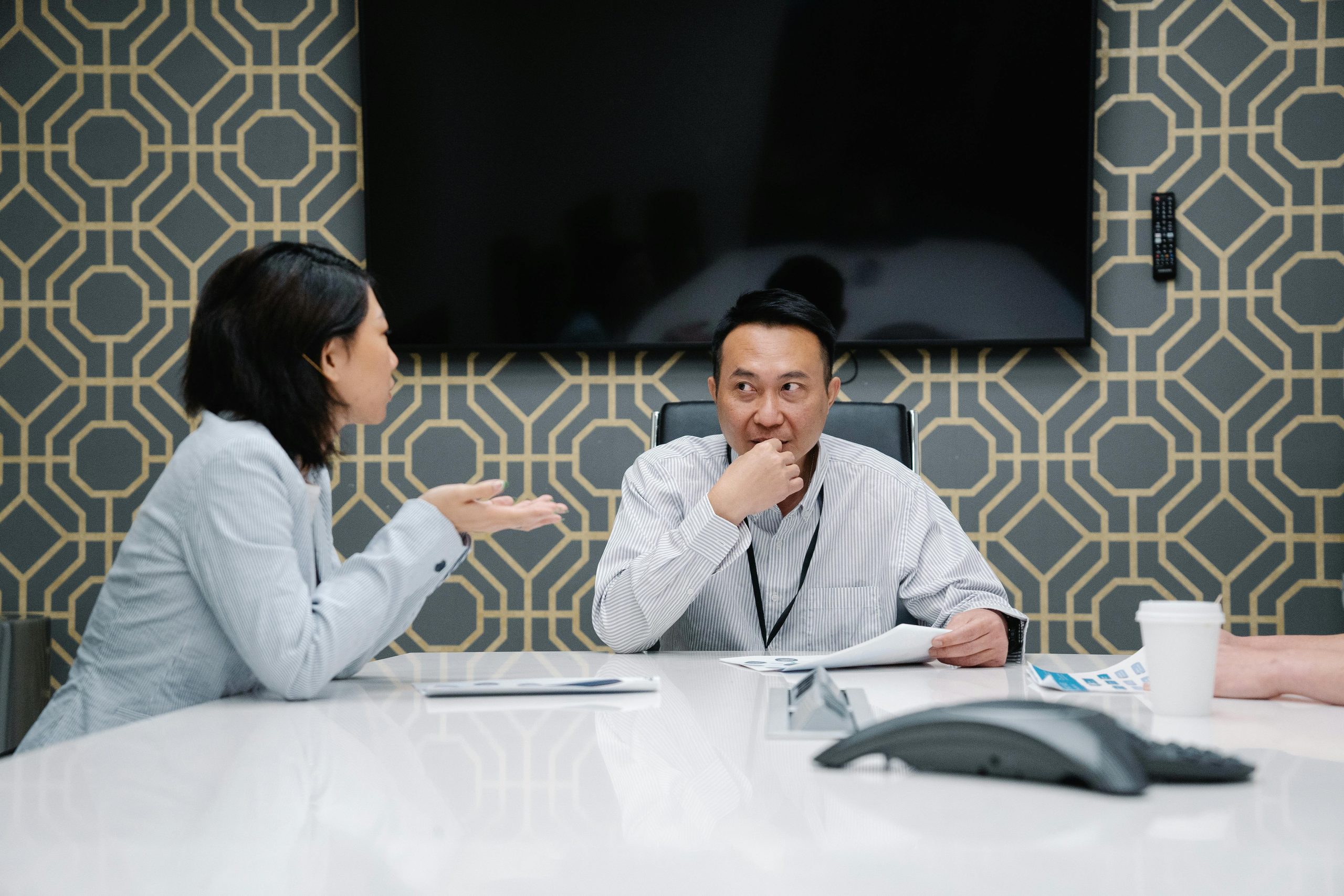Professionals engaged in a meeting discussing ideas around a modern conference table.