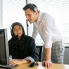 Two customer support agents working together in an office setting.