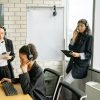 Professional women collaborating in a call center with headsets and computers.